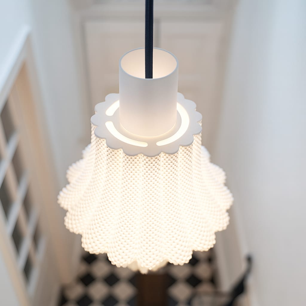 White textured pendant light hanging in a room with a blurred background