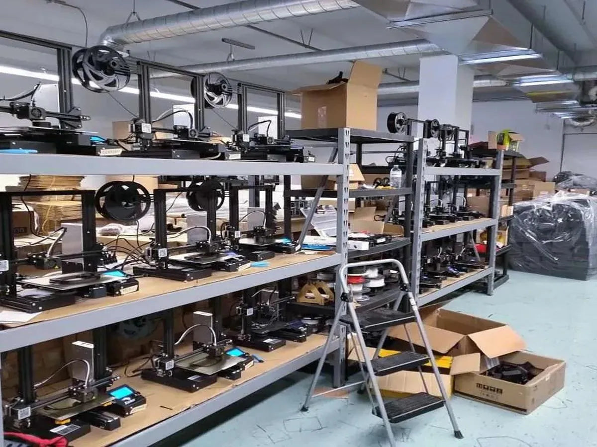 Room with multiple 3D printers on shelves and boxes on the floor