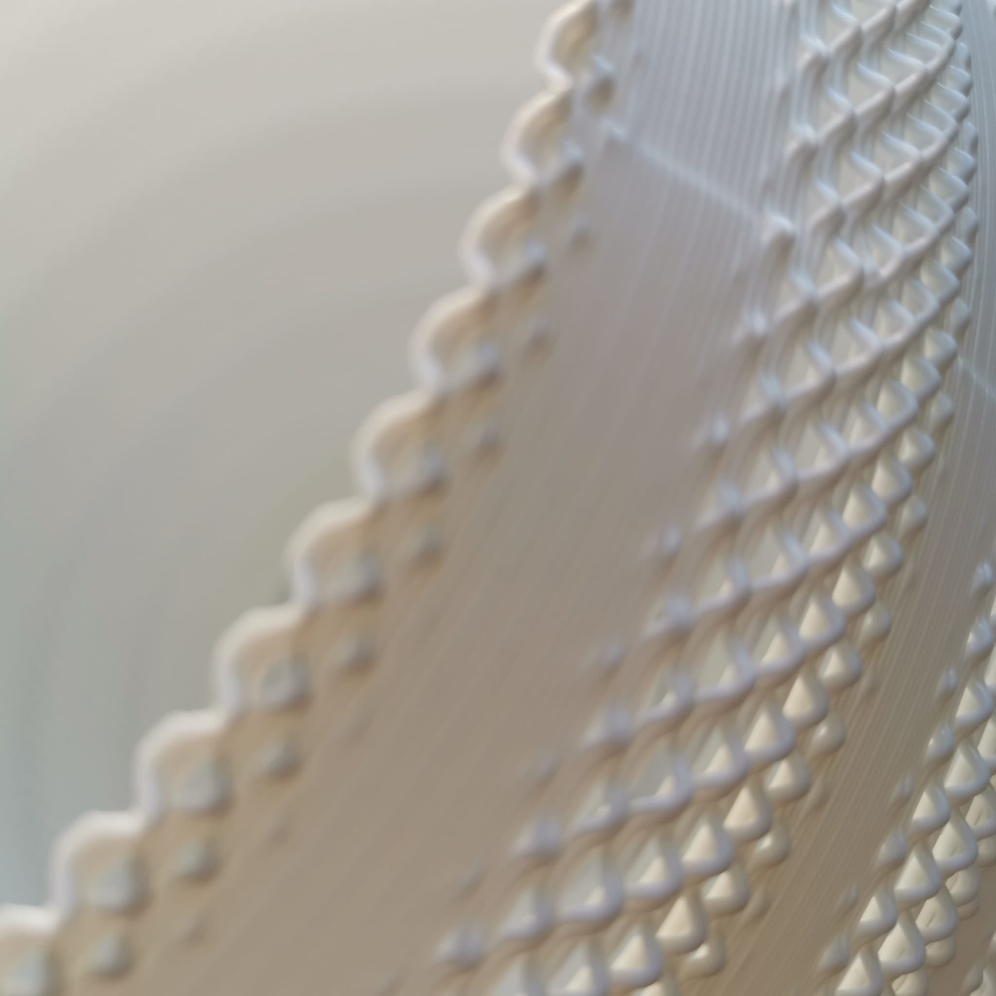 Close-up of a white fabric with scalloped edge on a light background