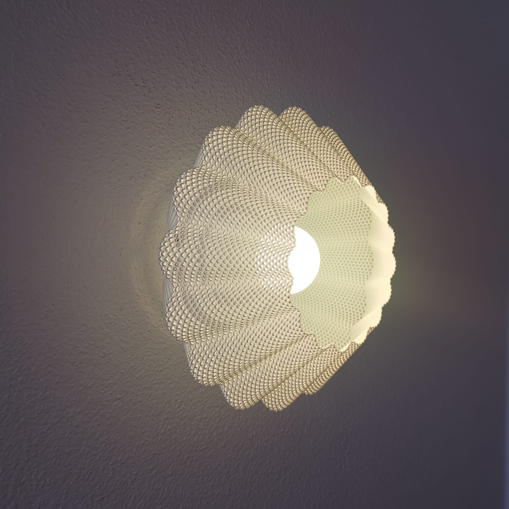 Modern wall light fixture with a textured design on a dark background